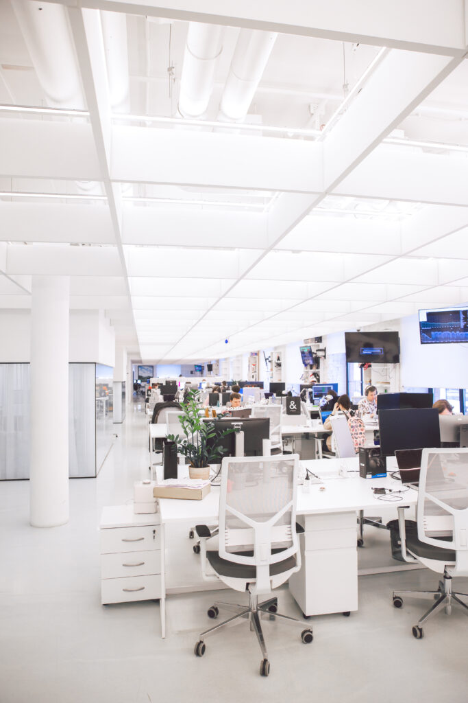 An open plan office with several empty chairs in the foreground.